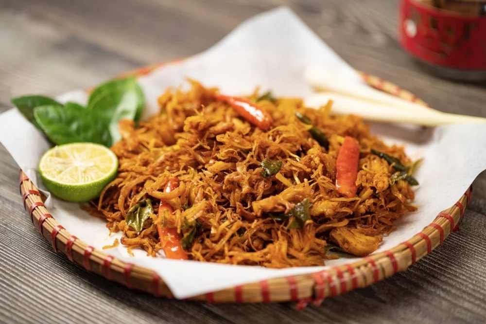 Khô gà xé sợi cùng lá chanh, ớt và chanh tươi trên mẹt tre
