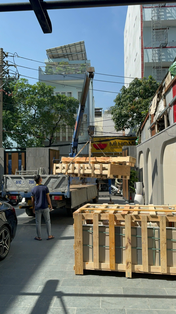 Nhân viên hỗ trợ cẩu và bốc xếp hàng đóng kiện gỗ tại Gia Phú